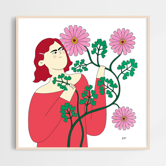 En rödhårig tjej tittar på en rosa, slingrig blomma med kärleksfulla ögon.
